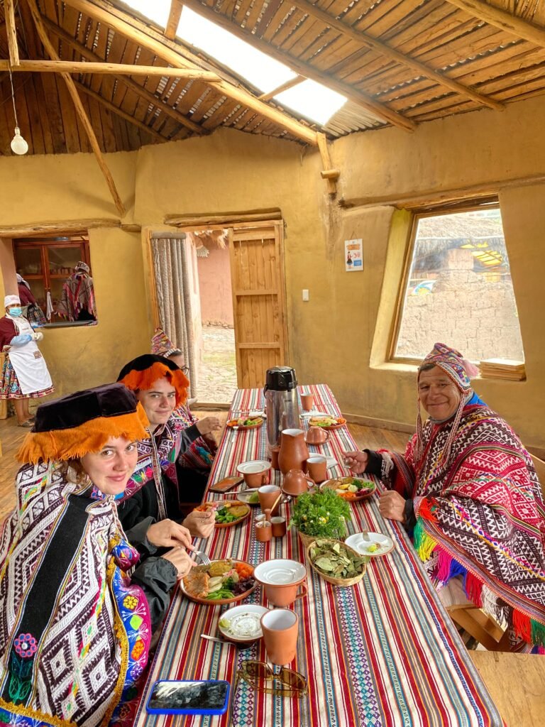 Viajantes e anfitrião em uma refeição compartilhada durante experiência cultural no Peru