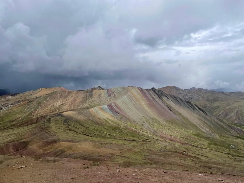 Viajante diante das montanhas coloridas de Palcoyo, na região de Cusco