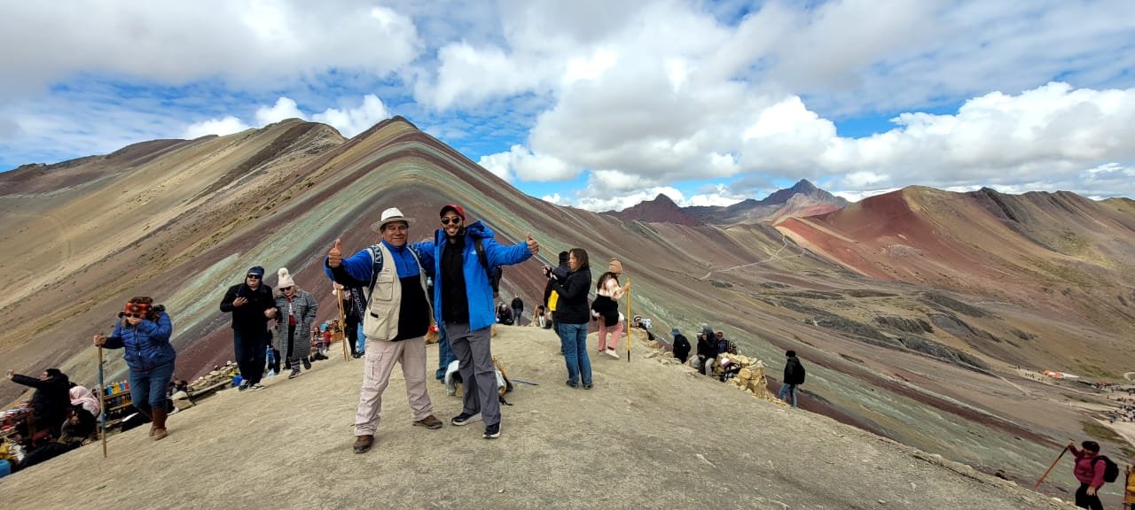 Viajantes diante da Montanha Arco-Íris Vinicunca, nos Andes perto de Cusco