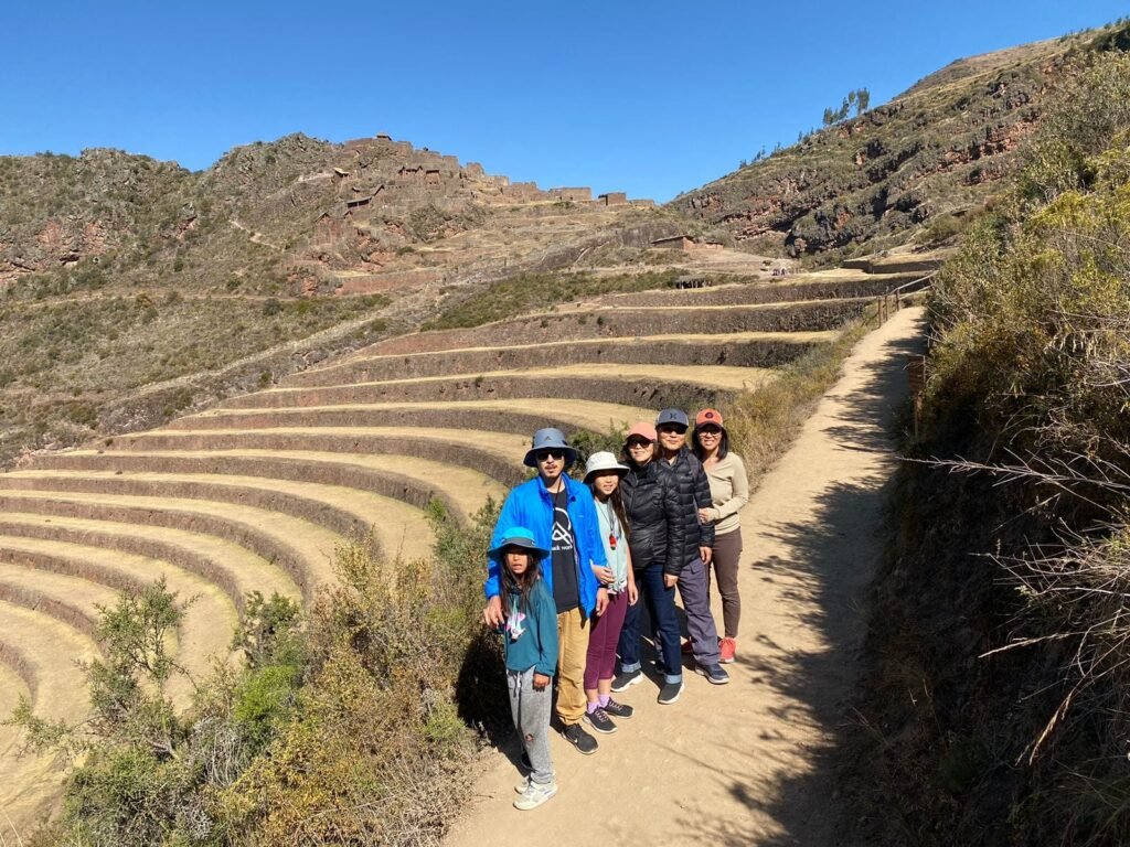 Viajantes diante dos terraços incas de Pisac, no Vale Sagrado