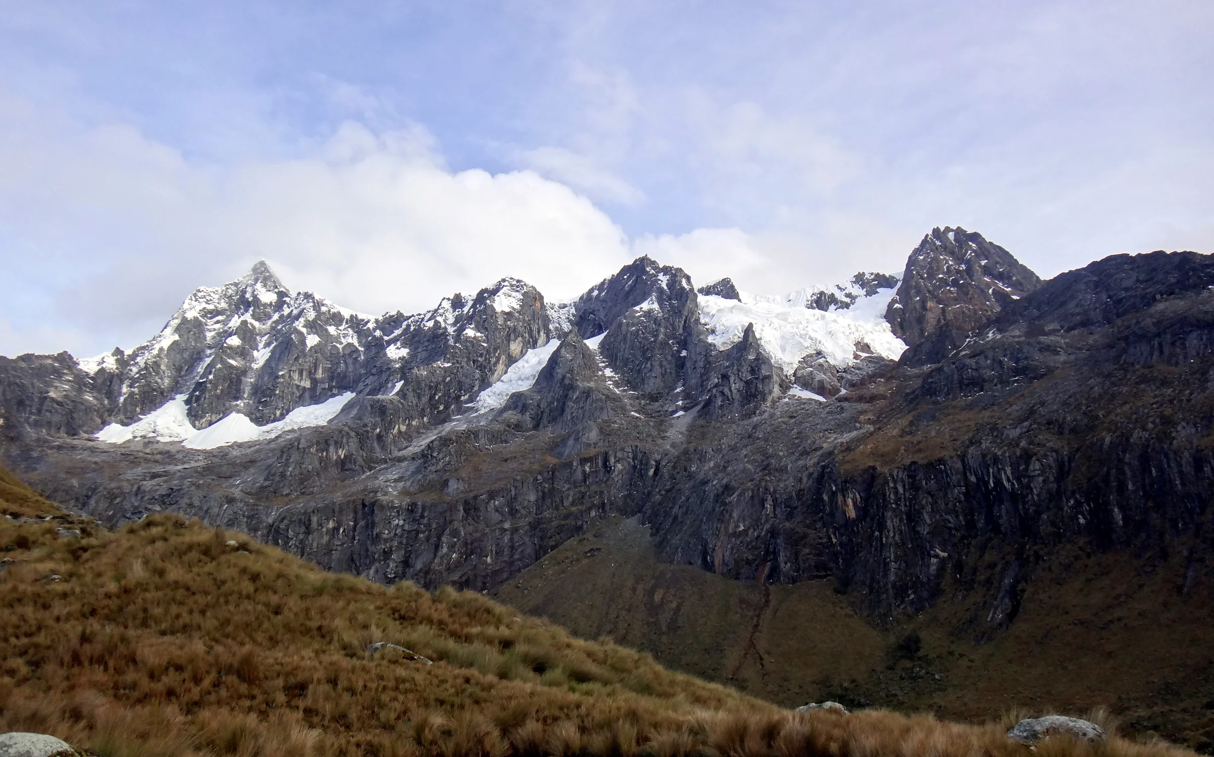 Vale de montanha na Cordilheira Branca, com encostas, rio e picos ao fundo
