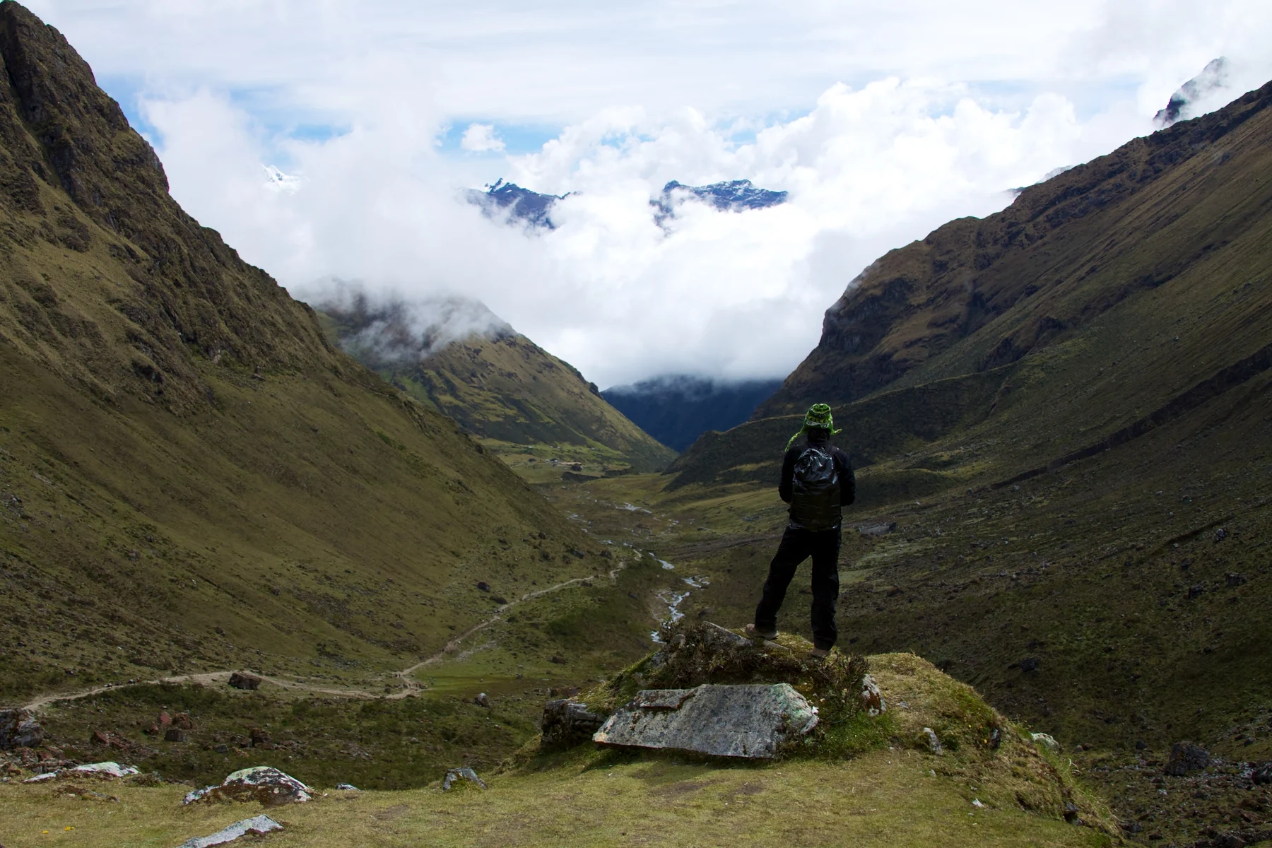 Caminhante observando um vale entre as montanhas da região de Salkantay