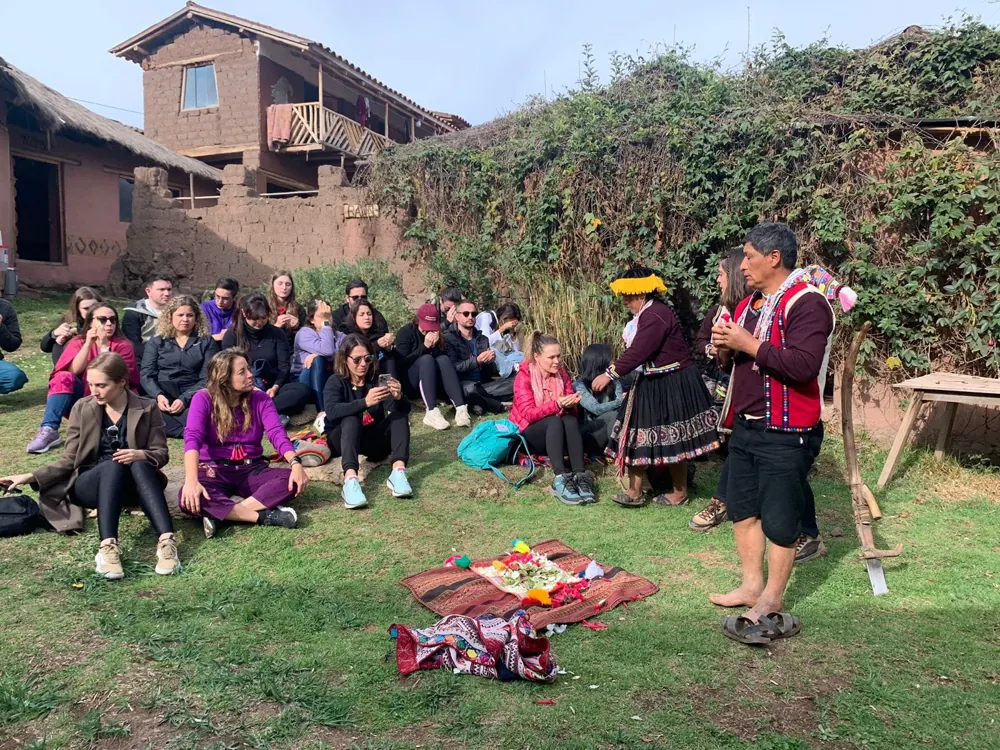 Viajantes acompanhando uma experiência cultural com moradores na região de Cusco